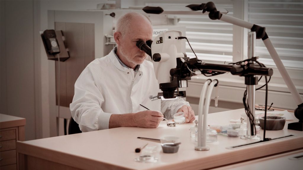 ARTESANO ESMALTADOR

Todos los oficios artísticos que se practican en Chopard Manufacture están destinados a embellecer un movimiento, una caja o una esfera, y esta artesanía se ejerce sobre la diminuta superficie de los relojes. Aunque todas estas habilidades son fascinantes, el esmalte Grand Feu es mágico. Christophe, artesano de la maison desde 2019, y el hombre que está detrás de este milagro de la miniaturización, revela algunos secretos de este arte en el que gracias a este tipo de esmalte, se puede reproducir la belleza de una peonía en una esfera –el temblor de sus pétalos y la sutileza de sus colores– utilizando solo polvo de esmalte, un poco de aceite, un kiln y un pincel. 
