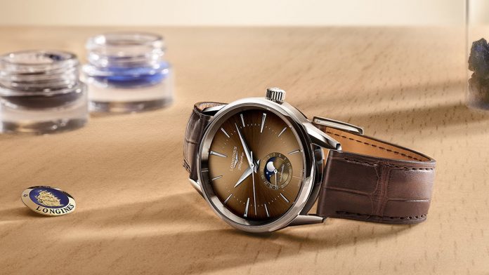 Longines presenta tres relojes únicos en beige habana, antracita y verde de su lujosa línea Flagship Heritage. jpg Como homenaje al modelo histórico Flagship de los años 50, los nuevos relojes de lujo cuentan con fase lunar y la firma de la colección: un medallón de oro de 18 K decorado con esmalte en el fondo atornillado de la caja.